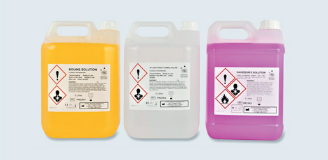 Three jerry cans containing different chemical solutions are displayed: one yellow labeled "Bourns Solution," one clear labeled "Electrolytic Control Solution," and one purple labeled "Daimond Solution." Each container has warning labels indicating safety hazards.